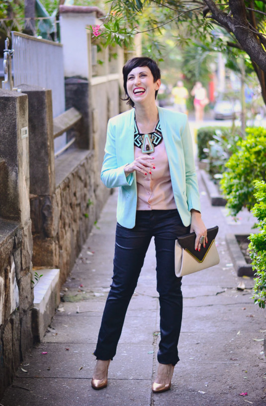 camisa rosa claro, blazer menta, calça preta, scarpin dourado e colar gigantesco de acrílico nas cores preto, rosa e menta