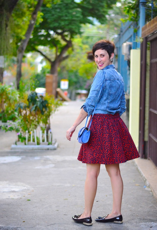 saia estampa oncinha vermelha com azul, mocassim com tessels envernizado marrom meio vinho, camisa jeans, bolsa pequena azul tiracolo