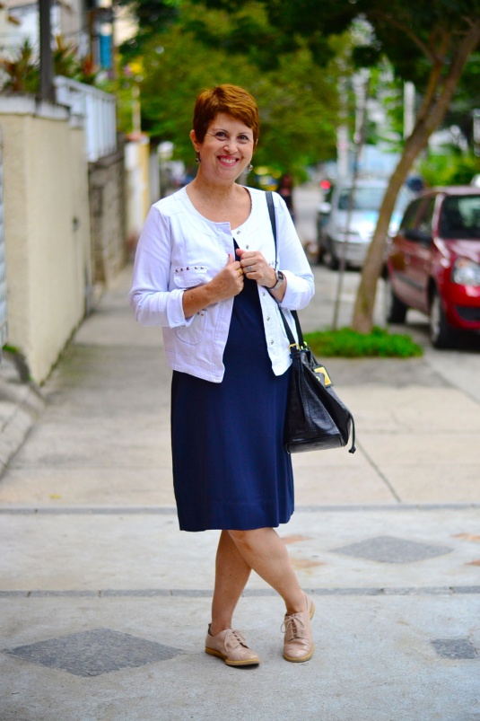 vestido de alça grossa de malha azul marinho até o joelho, jaqueta branca com tachas, bolsa saco preta de couro, oxford rosé