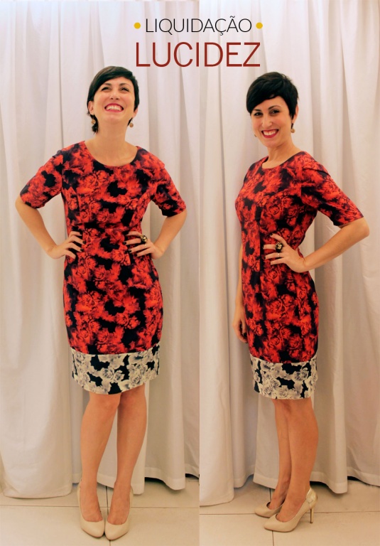 vestido acinturado com mangas cobrindo os braços e comprimento nos joelhos de rosas vermelhas em fundo preto e barra de rosas brancas