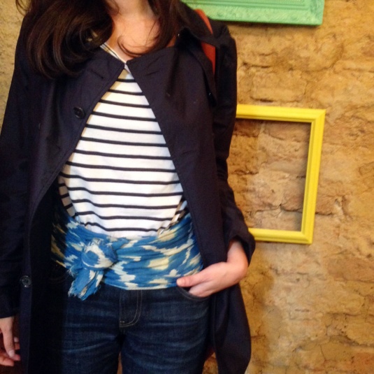 lenço de algodão azul e branco usado como faixa no quadril, blusa listrada navy, jeans e trench coat azul marinho