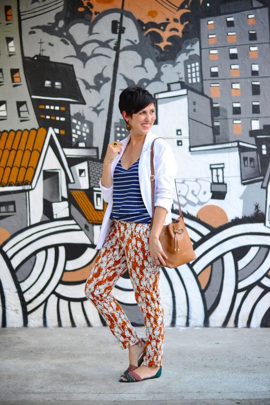 calça sequinha em laranja terroso com estampa pb de coelhos estilizados, regata azul marinho com listras brancas, blazer boyfriend branco de linho, sandália de tiras rasteira verde folha e telha, bolsa saco caramelo